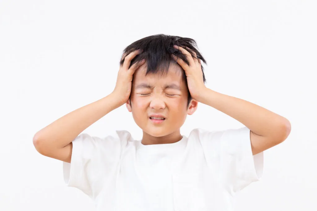 頭を抱えて困った表情をする男の子